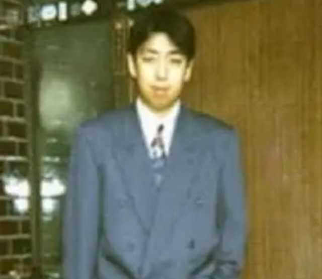 玄関前で写真に収まる若い頃の日村勇紀