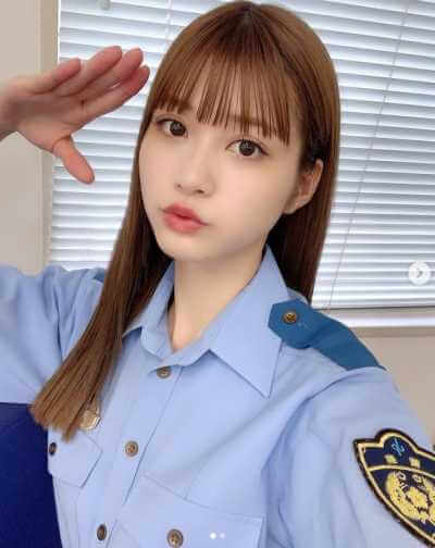 生見愛瑠が婦警の制服姿で敬礼をしている画像