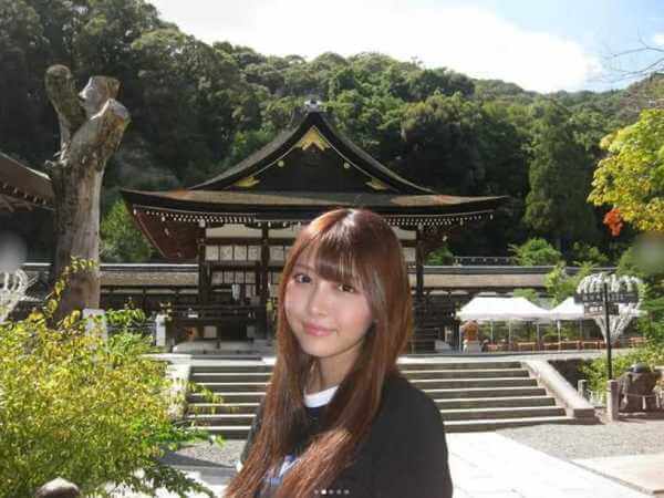 神社をバックに写真に収まる石川満里奈