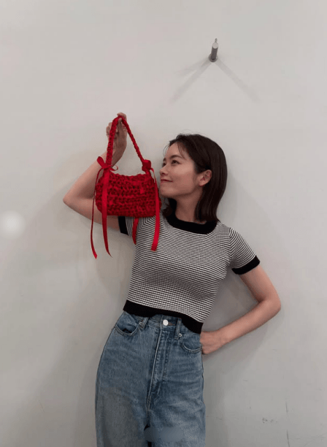 自分で編んだ赤いバッグを手に持つ小芝風花