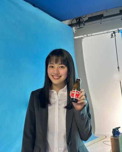 オロナミンCを手に持って笑顔の上坂樹里