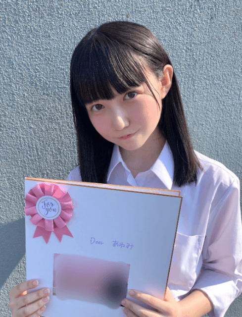 高校の同級生からの寄せ書きを持つ新居歩美