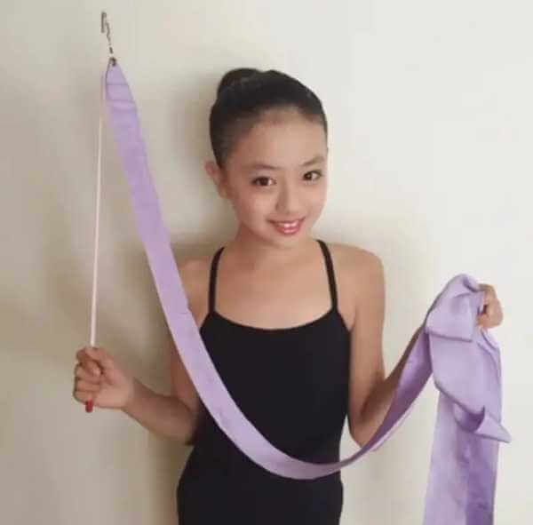 新体操のリボンを持ち、レオタードを着ている小学校時代の上坂樹里